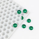 Durchscheinende grüne 2.6-mL-Halbkugel-Gummies neben der Silikonform mit 202 Kavitäten