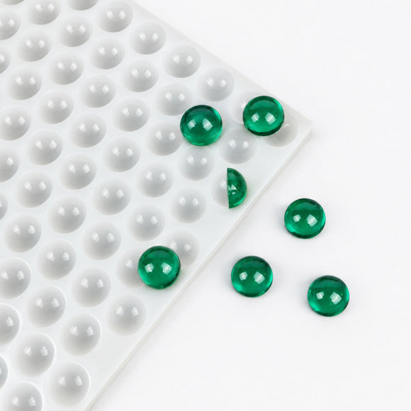 Durchscheinende grüne 2.6-mL-Halbkugel-Gummies neben der Silikonform mit 202 Kavitäten