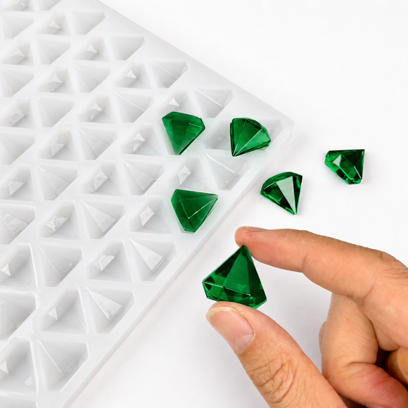 Hand met smaragdgroene diamantgummy naast de 2 mL vorm met 179 holtes