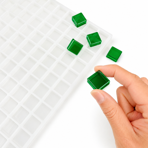 Afgewerkte vierkante gummy van 3.5 mL naast de vorm met 221 holtes gehouden