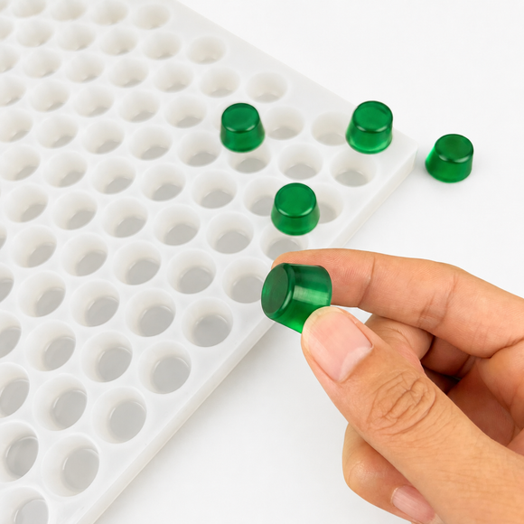 Hand mit smaragdgrünem Gumdrop-Gummy neben der 3-mL-Form mit 262 Kavitäten